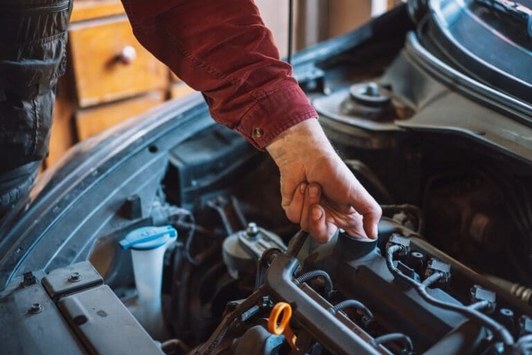 Mechanic checks with his finger for carbon deposits in the engine