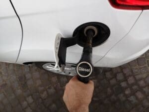 Top view of a man filling the car tank with diesel fuel at the gasoline station