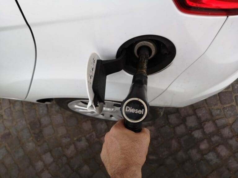 Top view of a man filling the car tank with diesel fuel at the gasoline station
