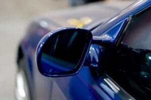 close-up At service station part of a BMW side mirror deep blue washed shiny metal
