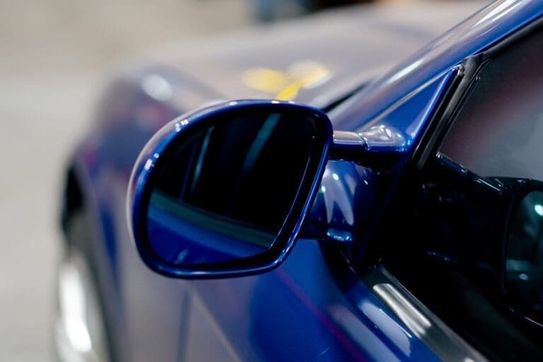 close-up At service station part of a BMW side mirror deep blue washed shiny metal