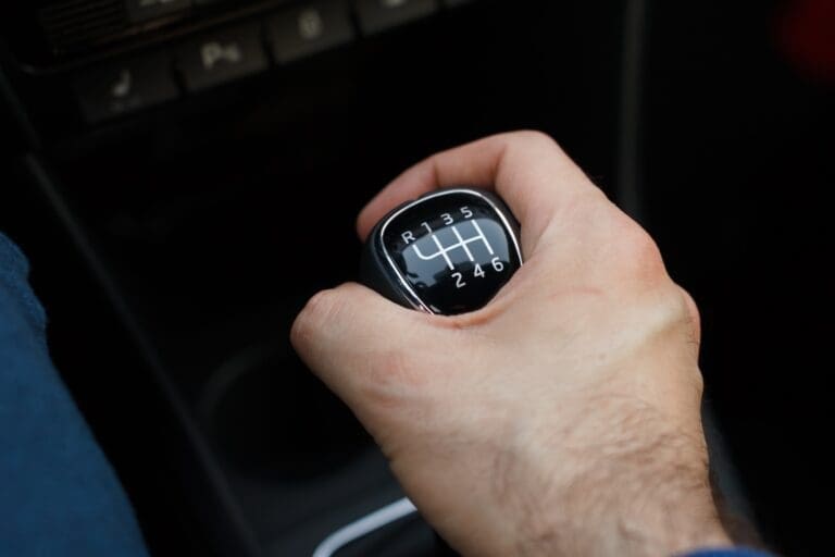 Man hand on a mechanical gearbox in the car. Man driving car. Car interior details. Car 6 speed