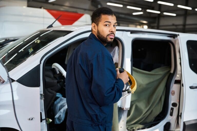 Handsome young mechanic working diligently in a well equipped garage during the day