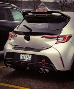 a silver car parked in a parking lot next to another car